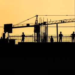 silhouette of people standing on tower crane during night time