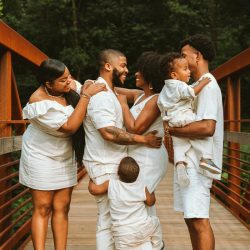man in white dress shirt carrying baby in white dress