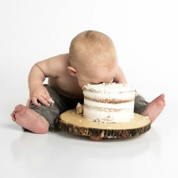 kid sitting beside round cake close-up photography